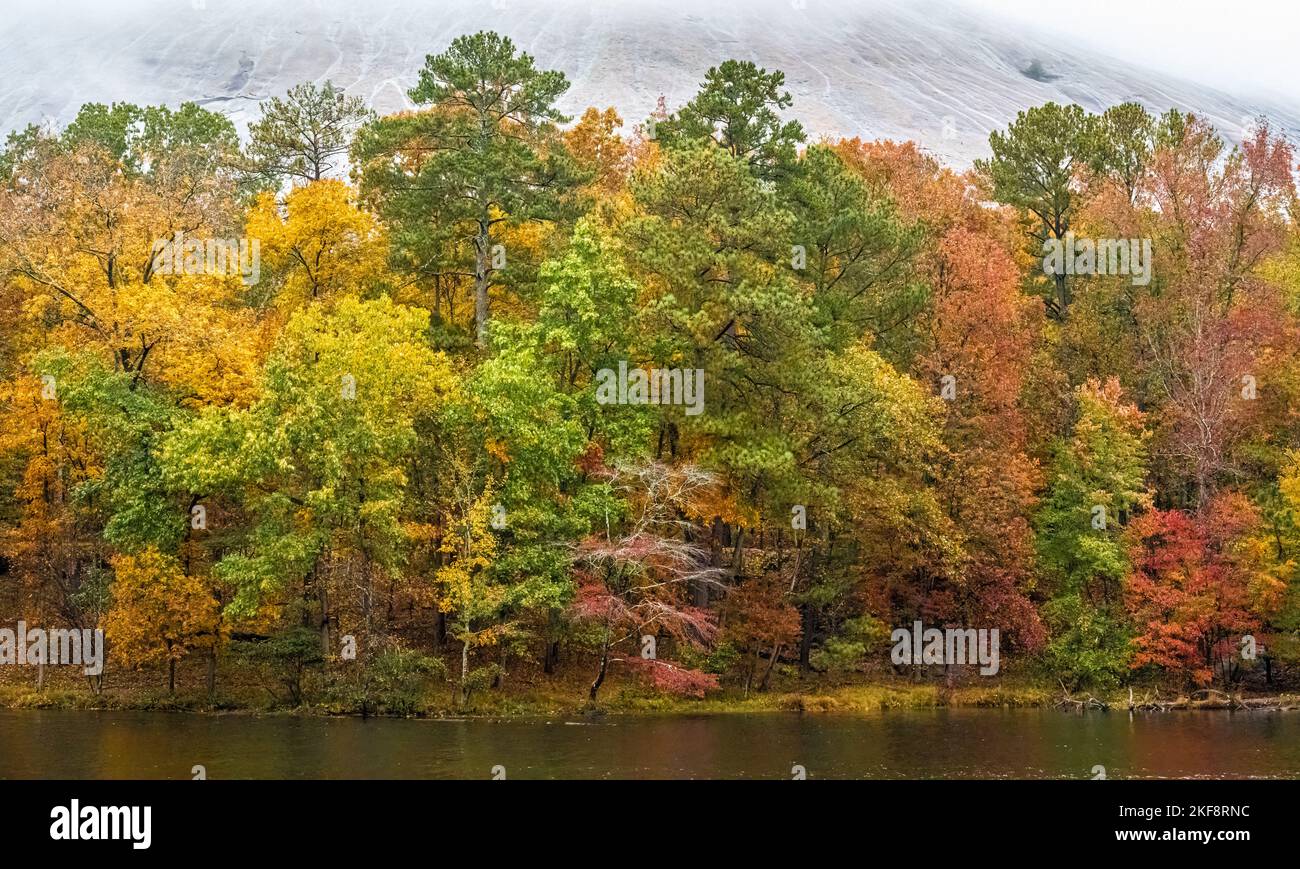 Herbstansicht von farbenfrohem Laub und einem nebelbedeckten Stone Mountain von einem Pfad am Seeufer im Stone Mountain Park in Atlanta, Georgia. (USA) Stockfoto