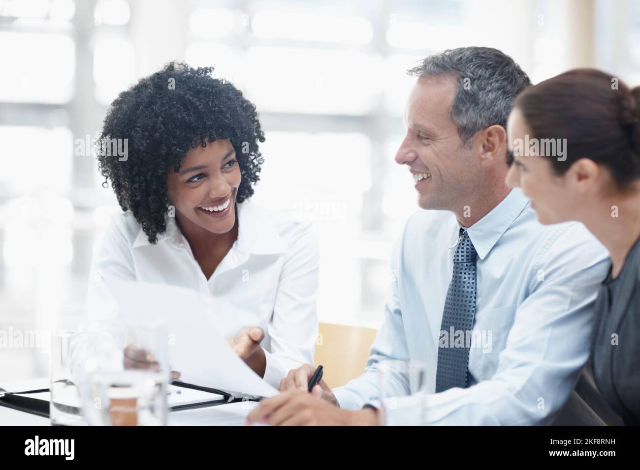 Diese Zahlen sind unglaublich. Eine vielfältige Gruppe von Mitarbeitern, die während eines Meetings über Geschäfte sprechen. Stockfoto