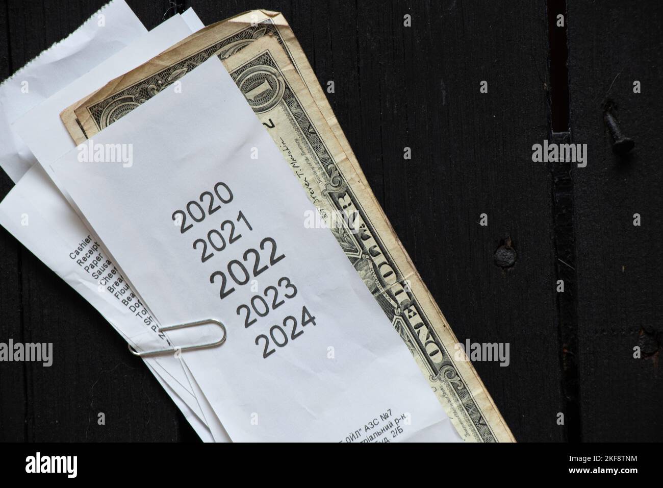 Liste der Jahre 2020 2021 2022 2023 auf der Kasse, die in der Nähe der amerikanischen Dollar liegt, Kaufbeleg und Geld, Finanzthema, Einnahmen im Jahr 2022 Stockfoto