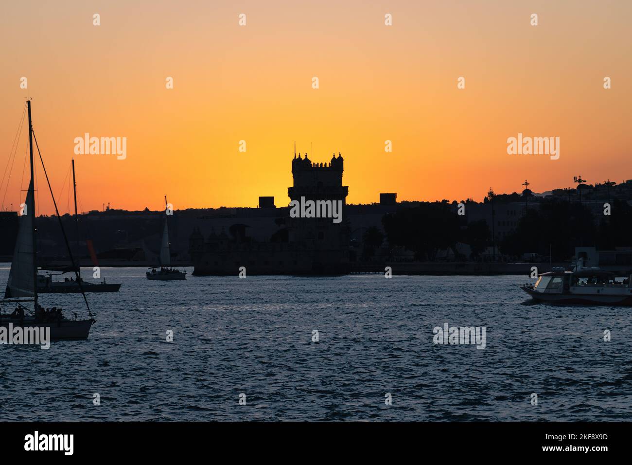 Sonnenuntergang über dem Fluss Tejo in Belém, Lissabon, Portugal. Die Silhouette des Belém-Turms, Torre de Belém. Festung aus dem 16.. Jahrhundert, UNESCO-Weltkulturerbe. Stockfoto