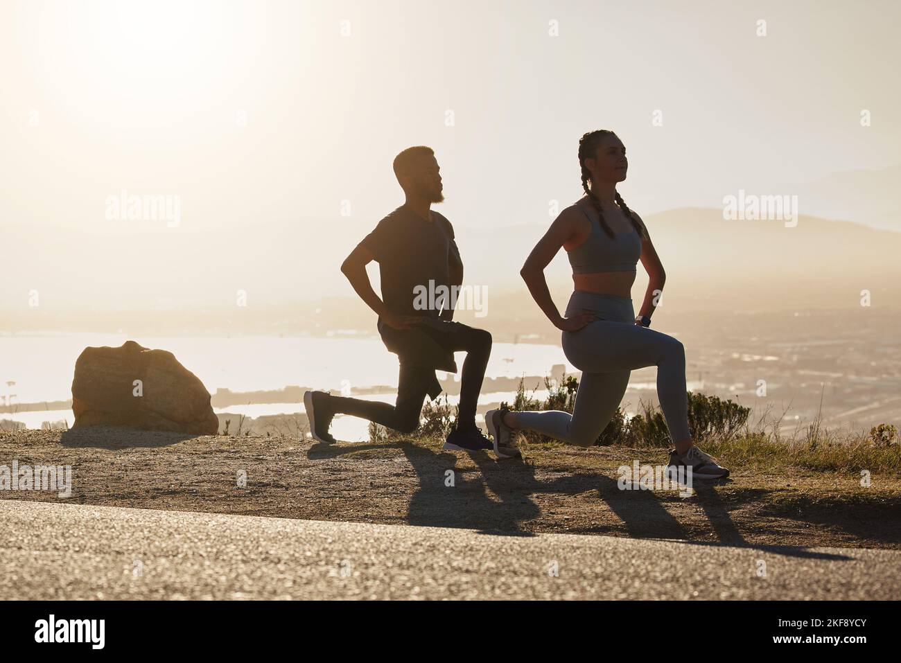 Fitness, Strand und Paar machen eine Ausfallschritt-Übung für Gesundheit, Wellness und Training in der Natur. Motivation, Sport und gesunde Männer und Frauen Athleten Stockfoto