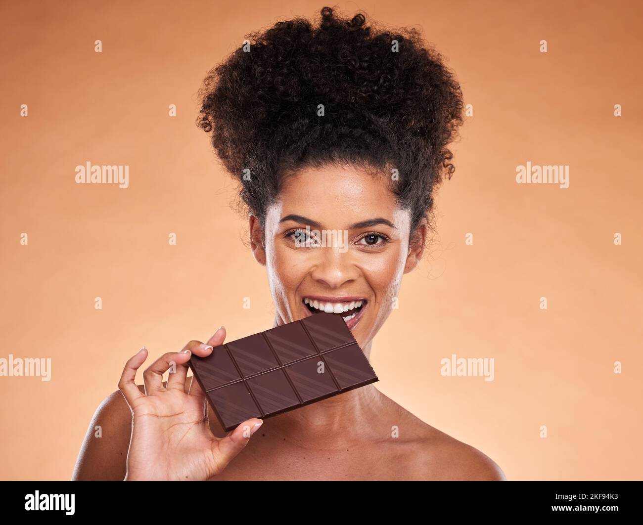 Schokolade, glückliche Frau und Beauty-Portrait, Studio Hintergrund und Süßigkeiten essen, Kakao Dessert und genießen Sie Zucker. Schwarze Frau beißen Schokoladenriegel, Kakao Stockfoto