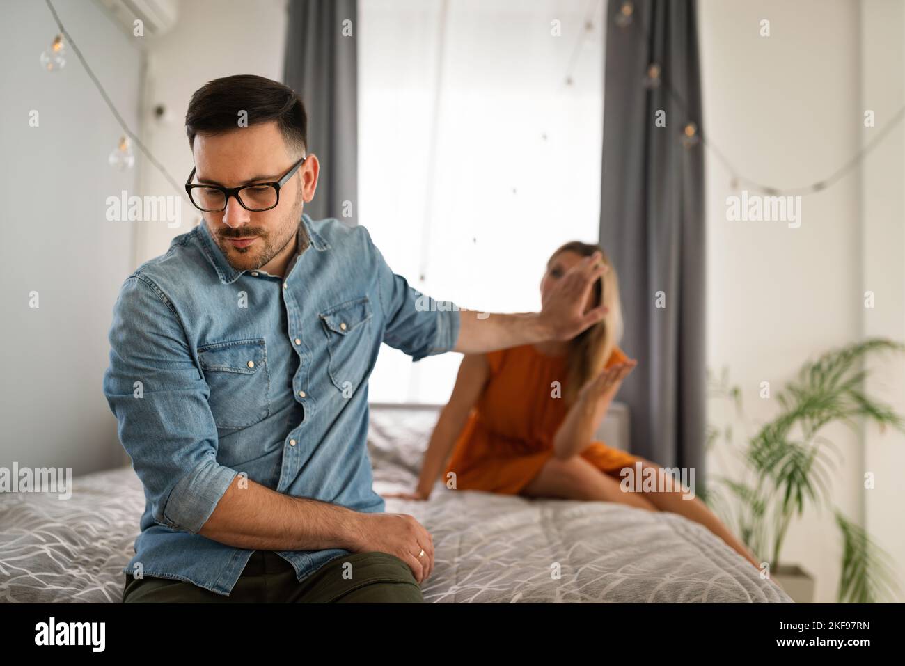 Traurige, nachdenkliche Paare, die an Beziehungsprobleme denken, die auf dem Sofa sitzen, Konflikte in der Ehe. Stockfoto