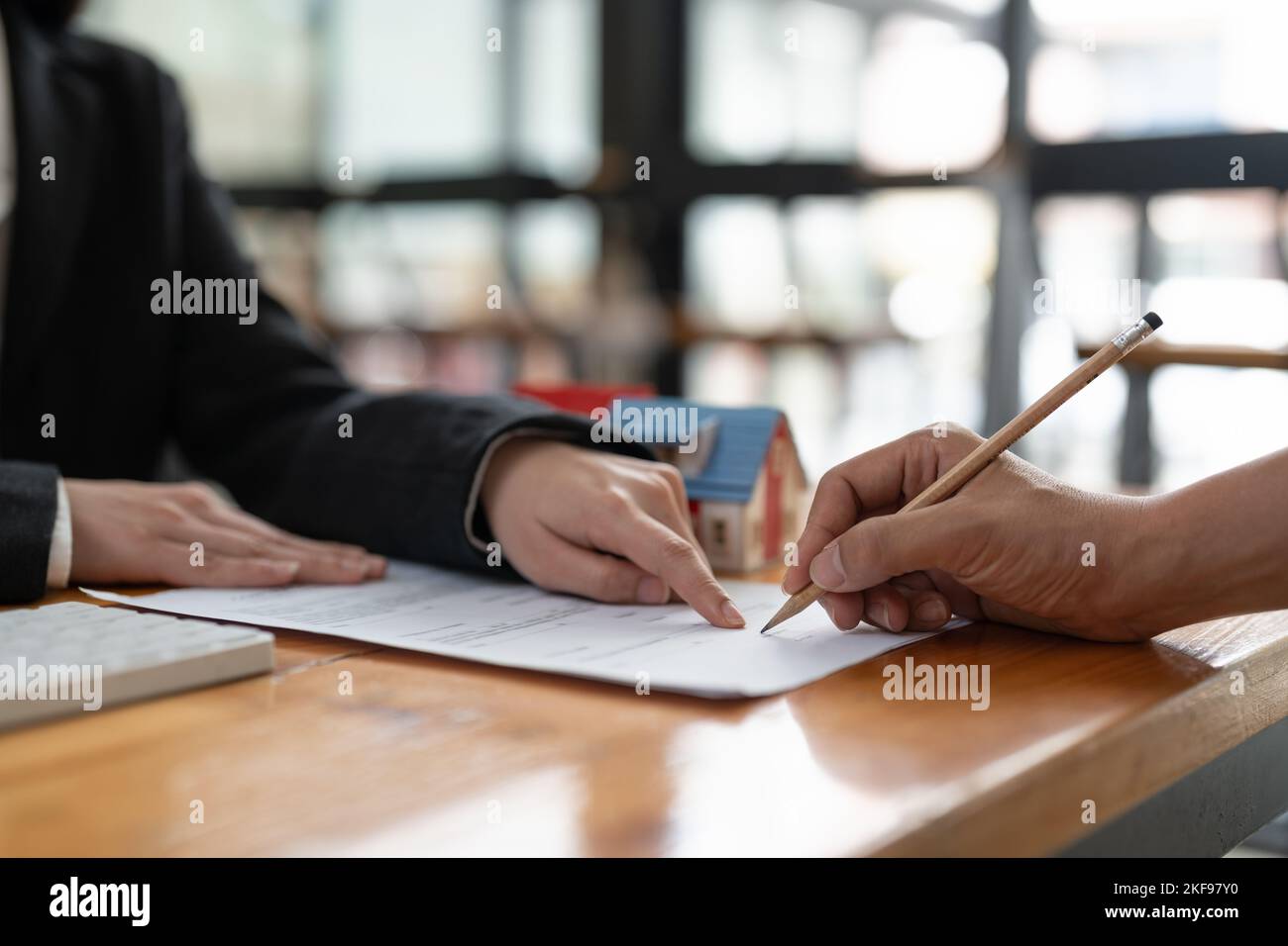 Immobilienmakler bieten Hand für Kunden unterzeichnen Vertrag Unterzeichnung für Kauf oder Verkauf Haus. Immobilien Konzept Kontakt Vereinbarung Konzept Stockfoto