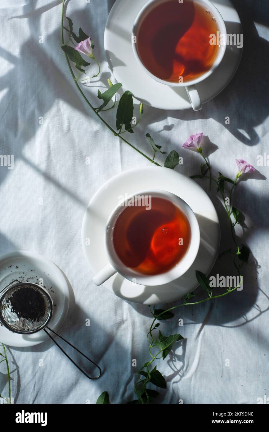 Stoffflachlage mit Teetassen und Weinreben, rustikale Ästhetik, Baumwollstoff Stockfoto