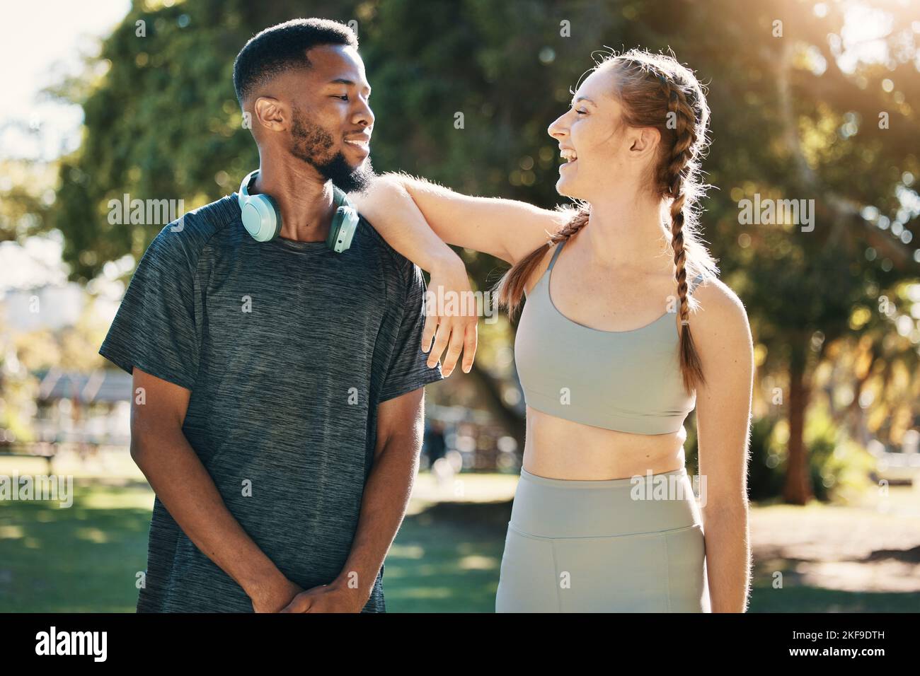 Fitness, Paare und Gespräche in der Natur nach dem Laufen, Training oder Training. Vielfalt, glücklicher Mann und Frau im Gespräch über Pause nach dem Training oder Stockfoto