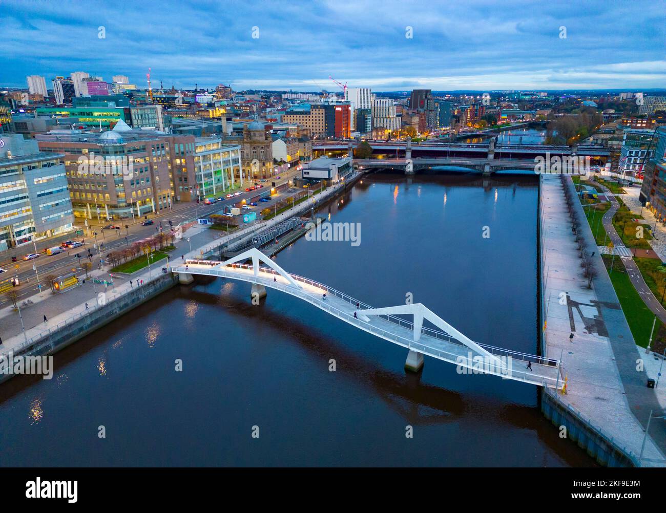 Luftaufnahme von der Drohne in der Dämmerung der Skyline von Glasgow und der Squiggly Bridge über den Fluss Clyde, Schottland, Großbritannien Stockfoto