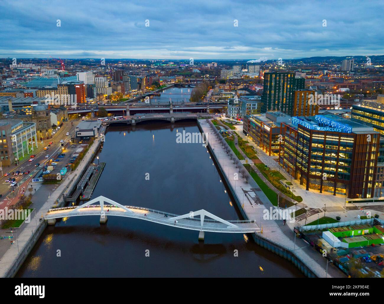 Luftaufnahme von der Drohne in der Dämmerung der Skyline von Glasgow und der Squiggly Bridge über den Fluss Clyde, Schottland, Großbritannien Stockfoto