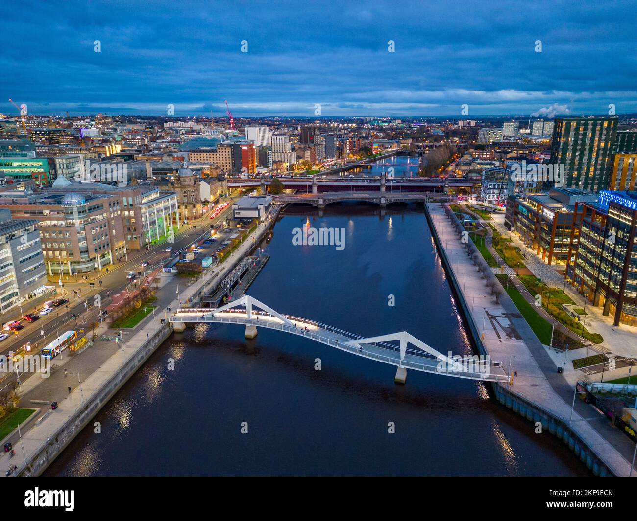 Luftaufnahme von der Drohne in der Dämmerung der Skyline von Glasgow und der Squiggly Bridge über den Fluss Clyde, Schottland, Großbritannien Stockfoto
