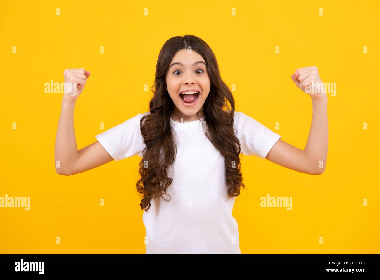 Teenager Kind überglücklich erfolgreich tun Sieger Geste Klench Faust sagen ja isoliert auf gelbem Hintergrund Studio. Aufgeregt teen Mädchen. Stockfoto