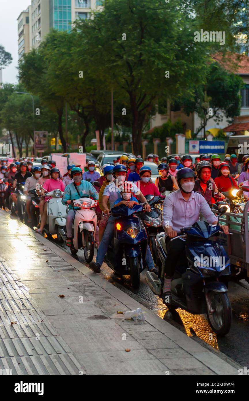 Saigon Street Life. Ein Motorradrundlauf schwärmen in Ho Chi Minh City in der Abenddämmerung Stockfoto