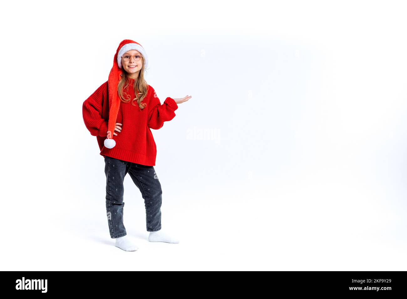 Junge schöne Mädchen trägt weihnachtshut über isolierten Hintergrund lächelnd fröhlich präsentiert und zeigt mit Handfläche Blick auf die Kamera. Stockfoto