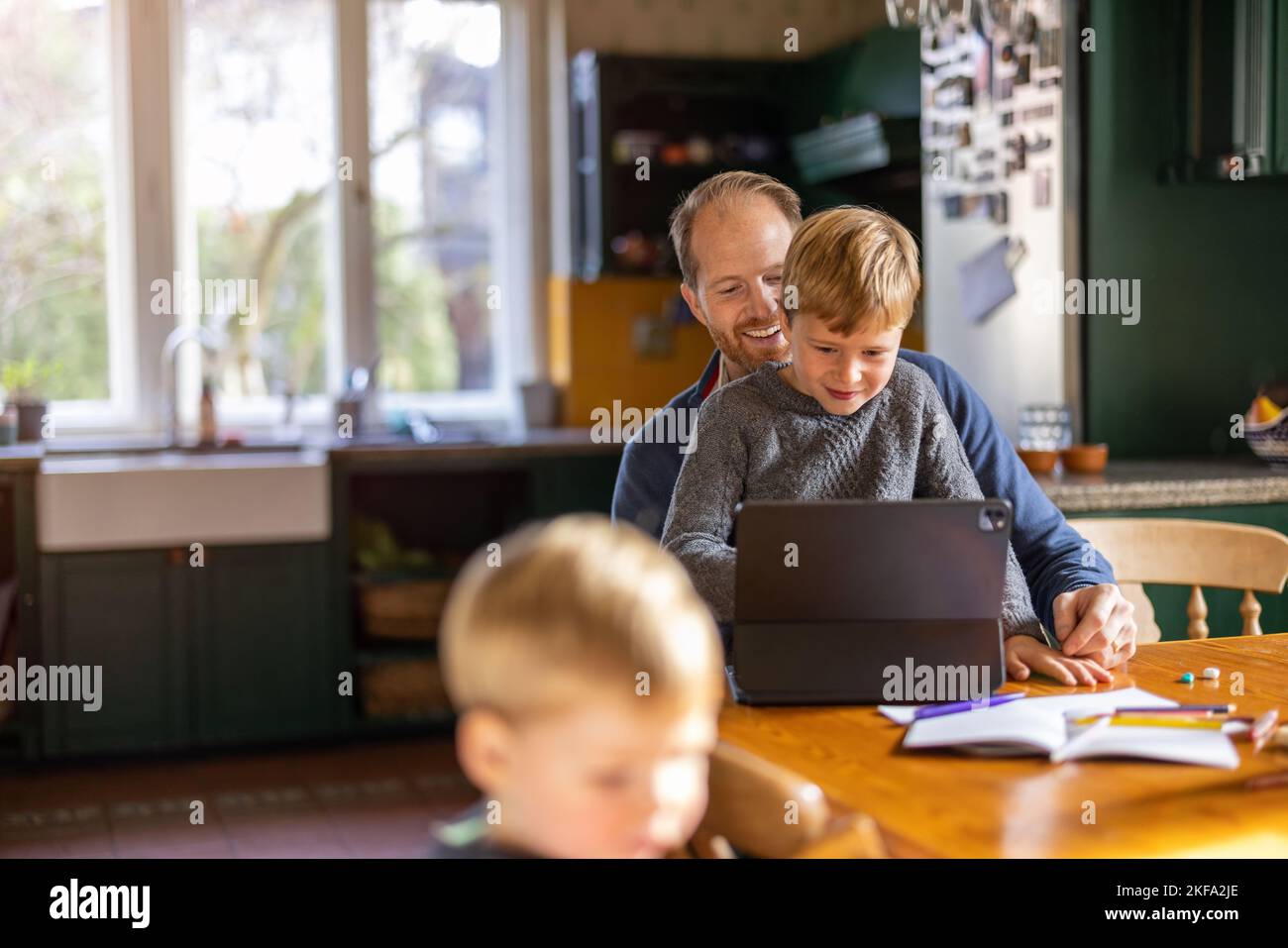 Papa mit Tablet zu Hause mit Kindern Stockfoto