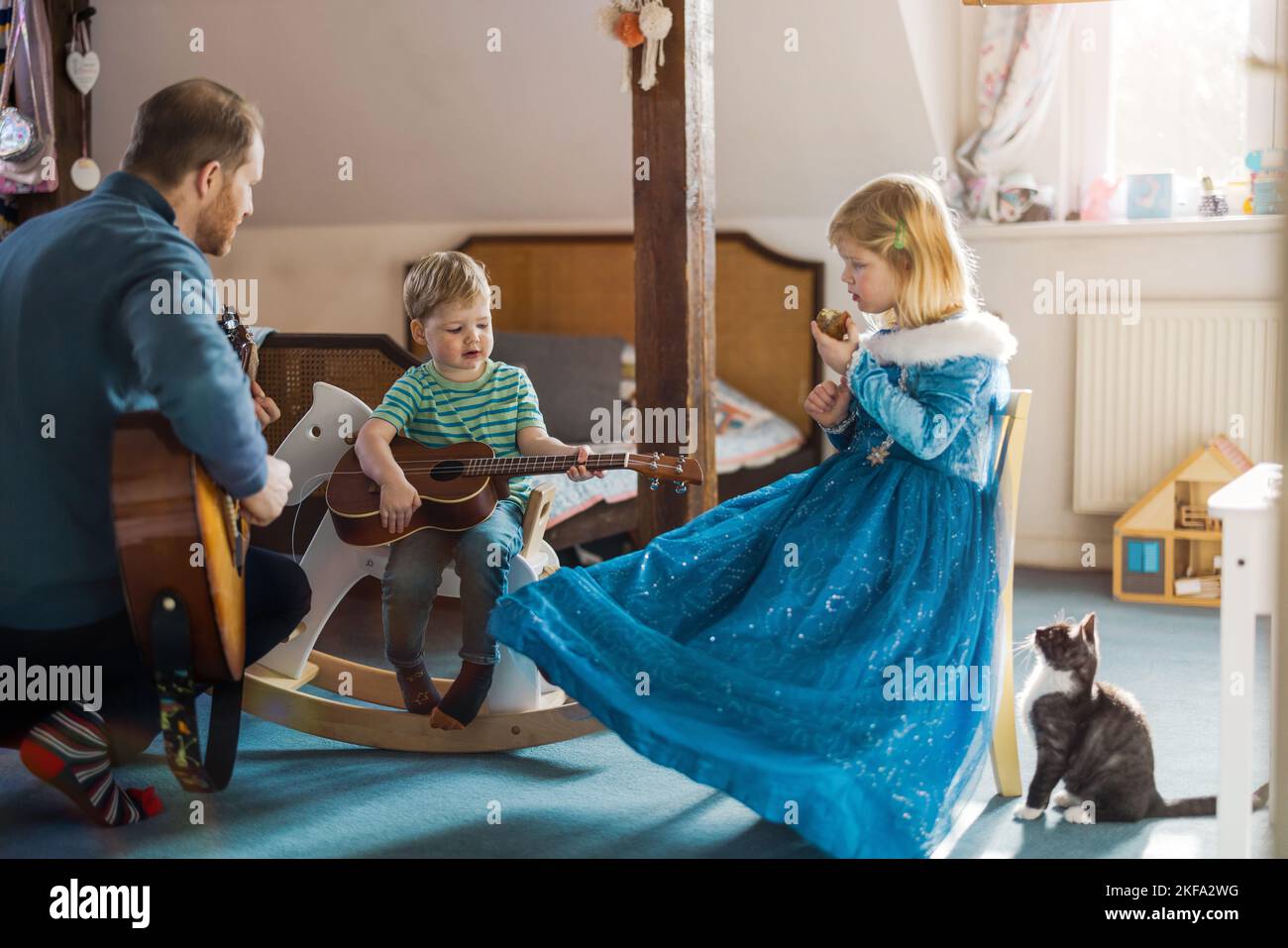 Papa lehrt seine Kinder, wie man Gitarre spielt Stockfoto