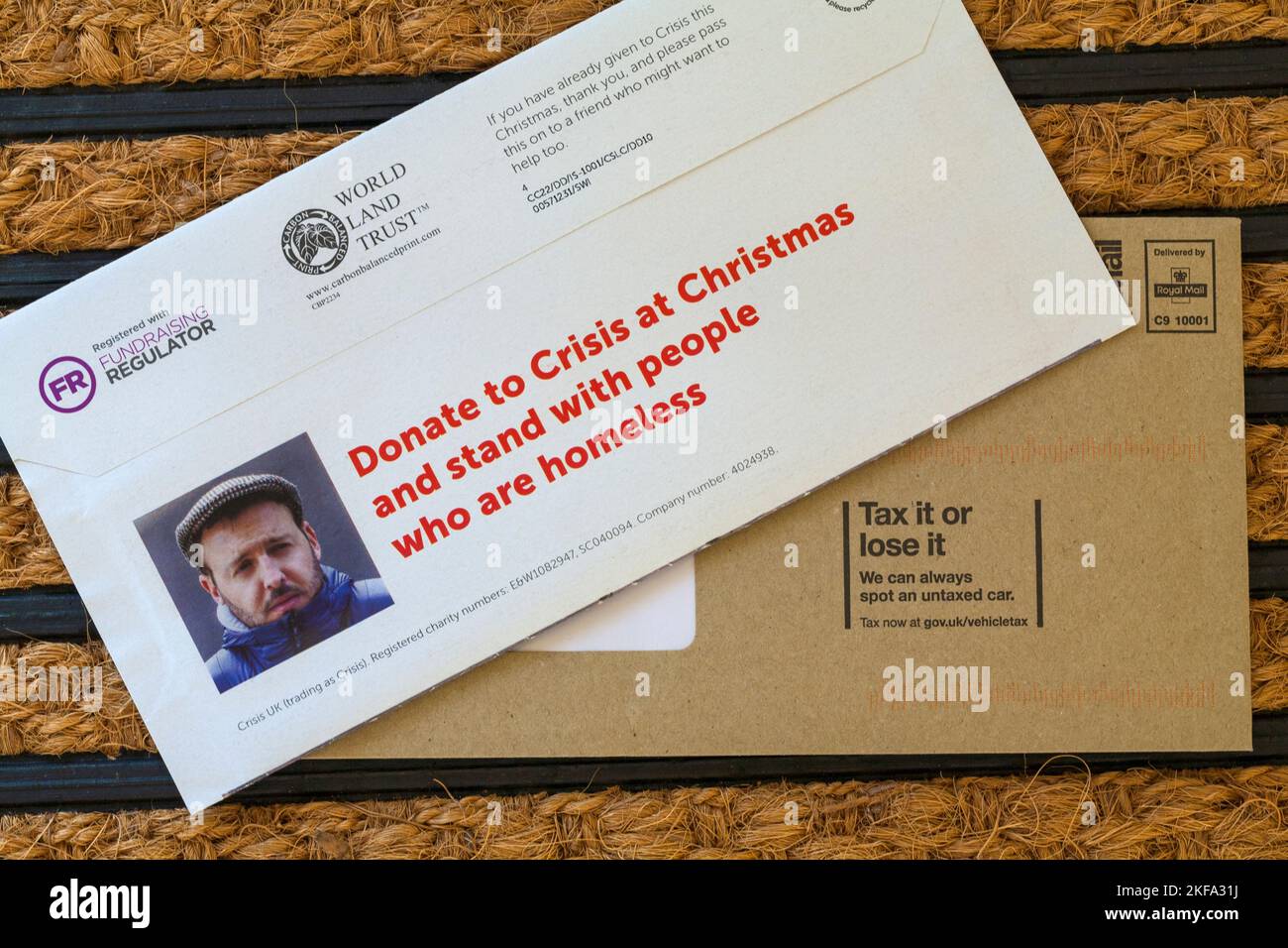 Post on doormat - Wohltätigkeitsaufruf aus der Krise, Spenden zur Krise zu Weihnachten und stehen mit Menschen, die obdachlos sind Stockfoto