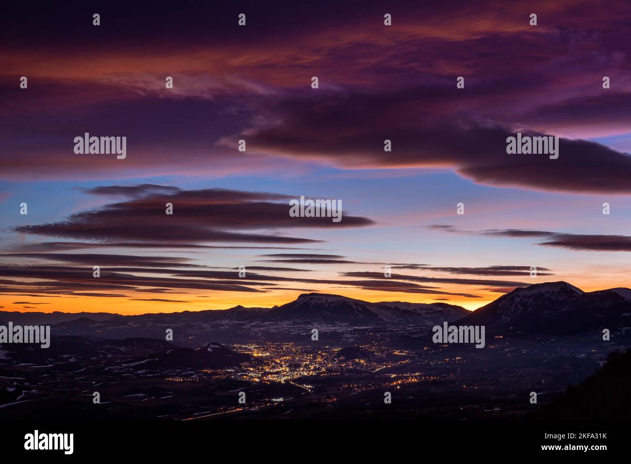 Feuriger Himmel bei Sonnenuntergang über der Stadt Gap mit den Bergen Charance und Ceuze in Silhoutte. Hautes-Alpes, Alpen, Frankreich Stockfoto