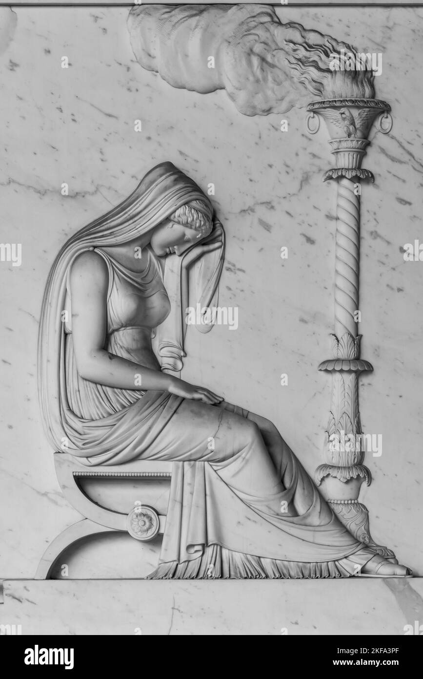 Schwarzweißfoto mit einer alten Illustration in einer Marmorwand, die eine traurige junge Frau darstellt, die auf einer Bank neben einem Scheiterhaufen sitzt Stockfoto
