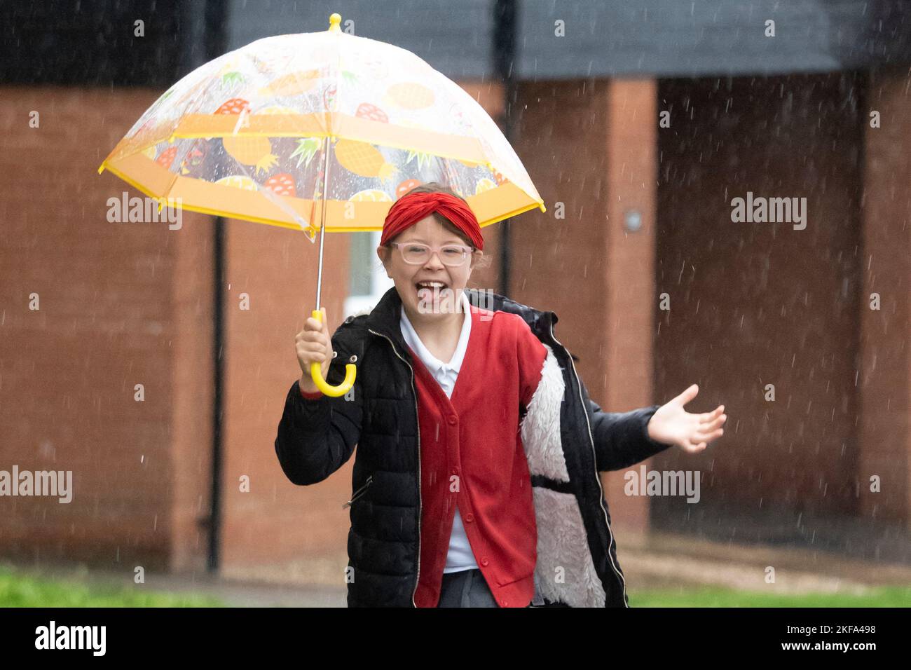 Haverhill, Suffolk, Großbritannien. 17.. November 2022. Ivy Mitchell, 7 tanzt bei starkem Regen und Wind, als sie heute Morgen zur Schule geht. Kredit: Headlinephoto/Alamy Live Nachrichten. Stockfoto