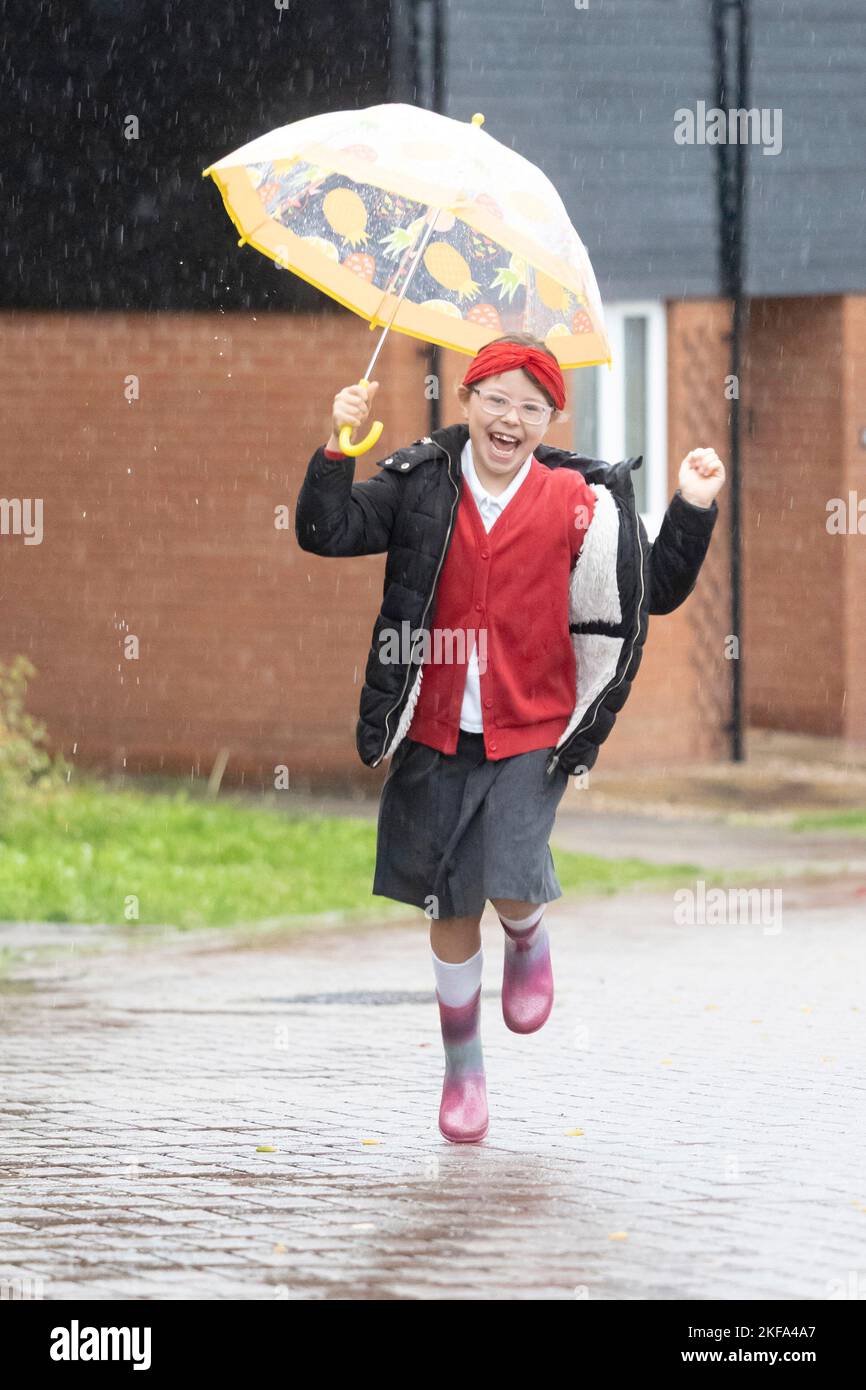 Haverhill, Suffolk, Großbritannien. 17.. November 2022. Ivy Mitchell, 7 tanzt bei starkem Regen und Wind, als sie heute Morgen zur Schule geht. Kredit: Headlinephoto/Alamy Live Nachrichten. Stockfoto