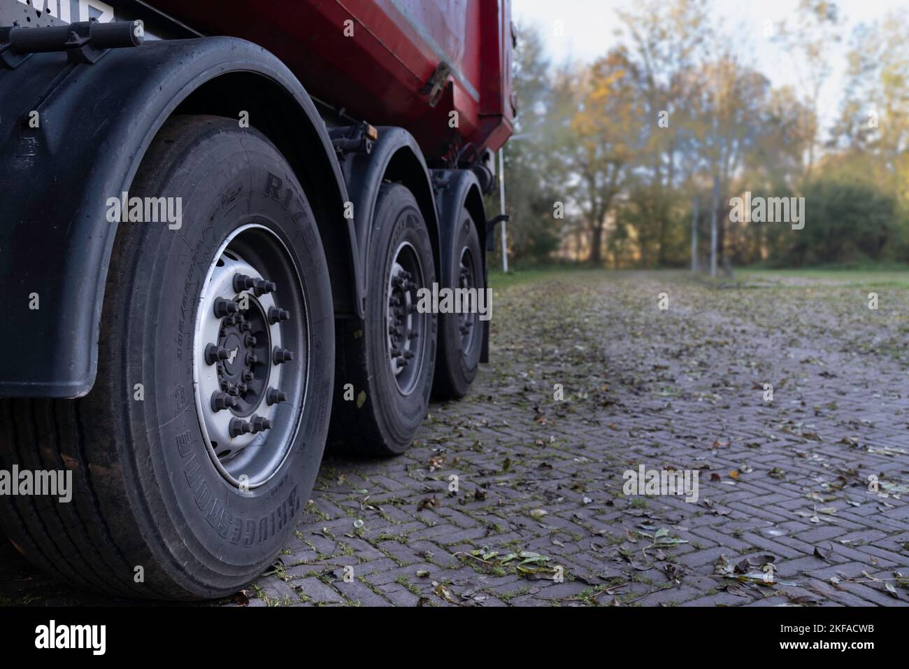 Sattelauflieger eines LKW mit großen Reifen, von der Seite nach hinten auf einer Straße betrachtet. Güterverkehr. Der richtige Platz für Text oder Design Stockfoto