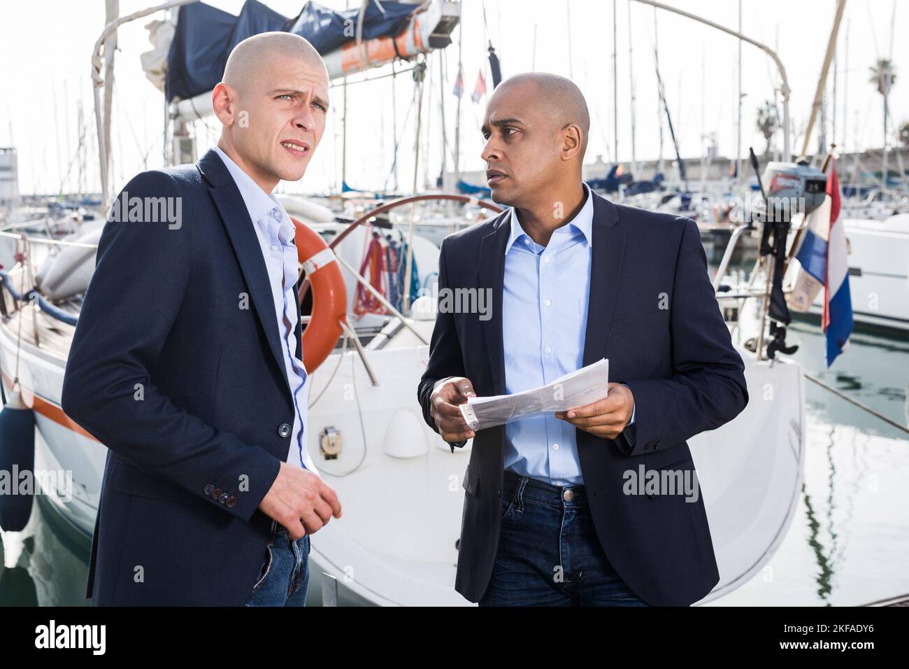 Zwei männliche Geschäftsleute vereinbaren einen Deal am Seehafen Stockfoto