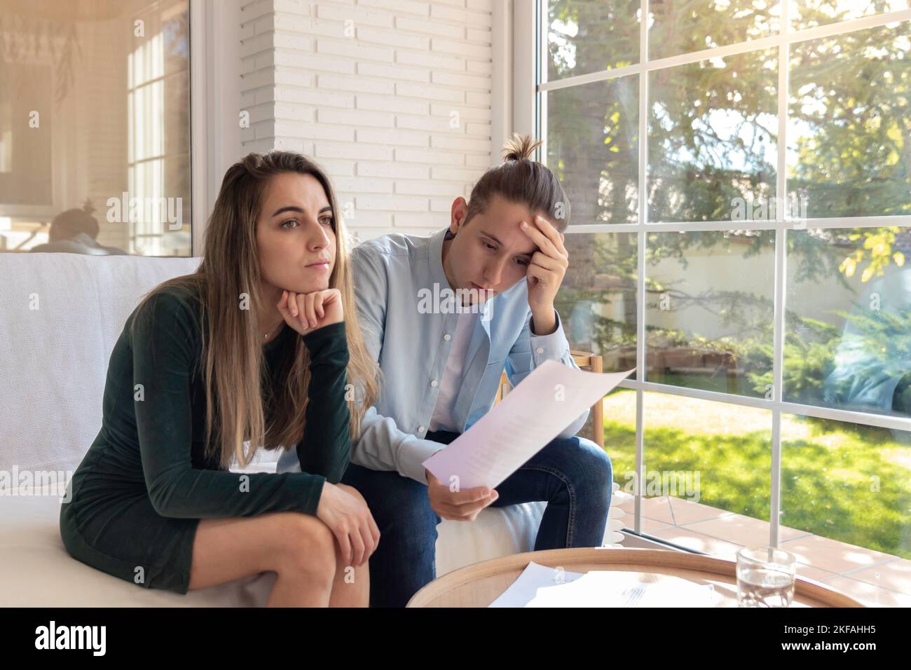 Verzweifeltes junges Paar hat kein Geld, um Schulden zu bezahlen, Miete für Wohnung zu bezahlen. Halten Kopf, kann keine Rechnungen bezahlen, mit finanziellen Schwierigkeiten. Haushalt Stockfoto