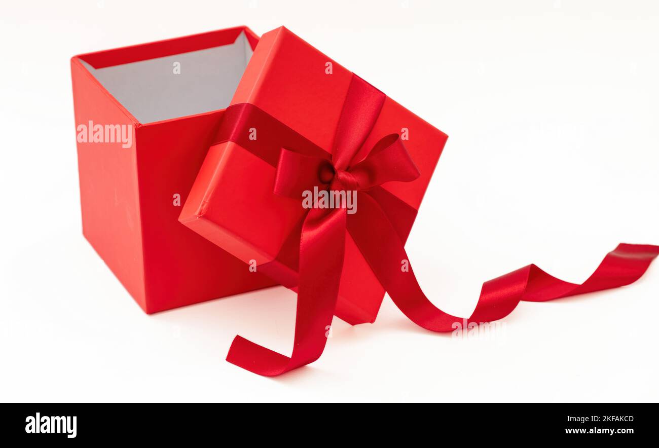 Rote Geschenkbox mit Band und Schleife offen isoliert auf weißem Hintergrund, Weihnachtsgeschenk Stockfoto