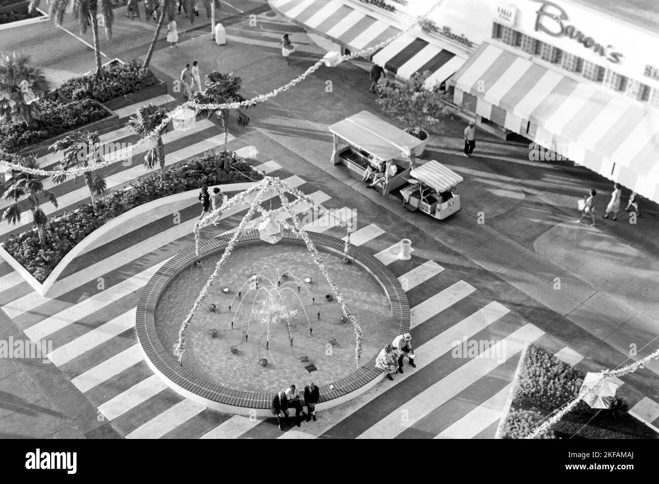 Menschen am Springbrunnenrand in der Lincoln Road in Miami Beach, Florida, USA 1965. Menschen am Brunnenrand der Lincoln Road in Miami Beach, Florida, USA 1965. Stockfoto