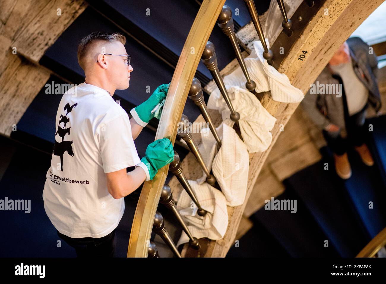 17. November 2022, Bremen: Philipp Neumann aus Thüringen, Teilnehmer des nationalen Wettbewerbs im Bereich Gebäudereinigung, reinigt im Haus des Reiches ein Treppengeländer aus Messing. Beim jährlichen Wettbewerb treten Gesellen aus mehreren deutschen Bundesländern in verschiedenen Disziplinen der Gebäudereinigung gegeneinander an. Foto: Hauke-Christian Dittrich/dpa Stockfoto