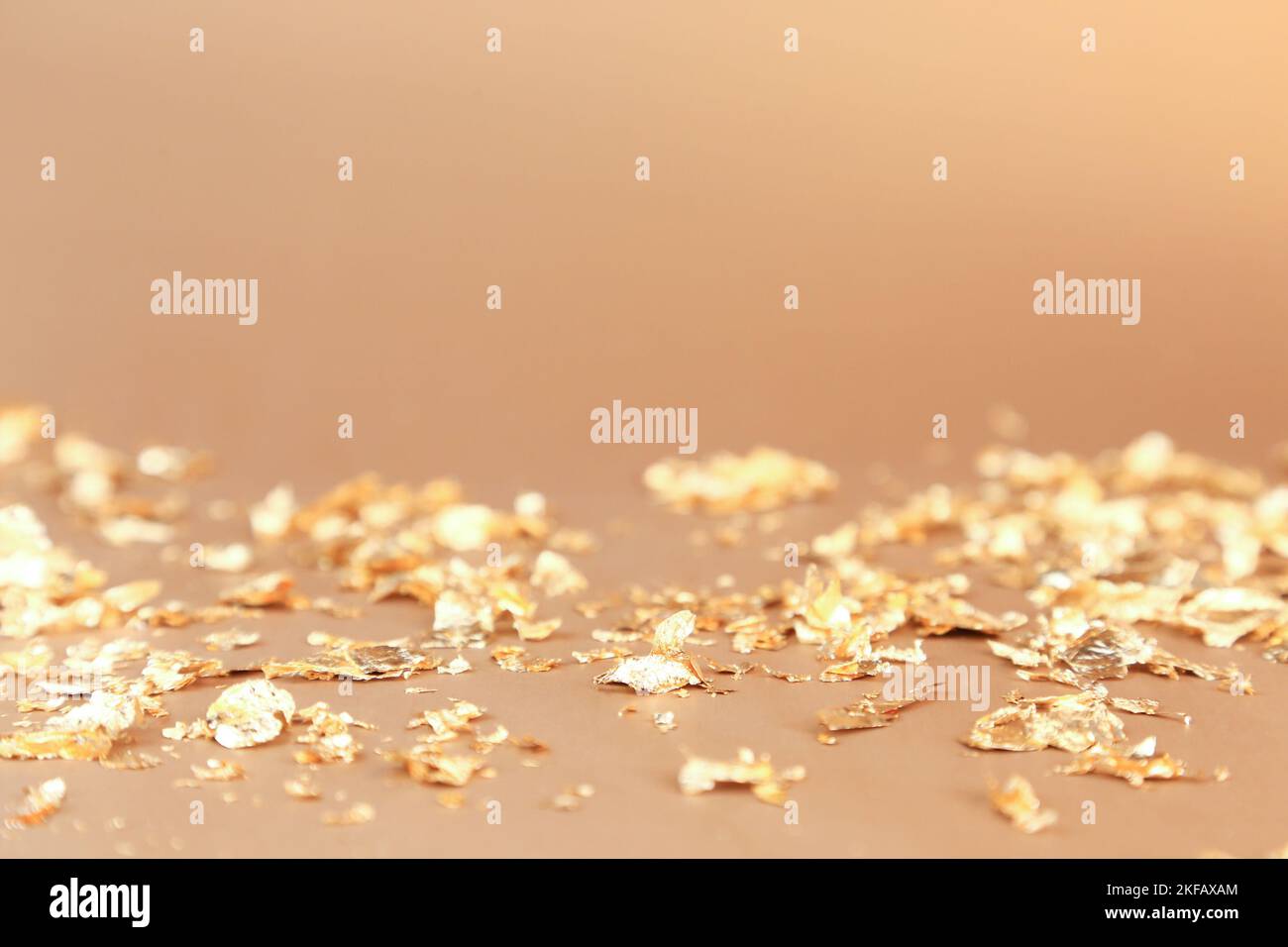 Hintergrund der Werbung für Kosmetikprodukte. Stücke von goldenem Papier-Feuerwerkskörper auf goldenem Hintergrund. Leerer Ort für die Anzeige der Produktverpackung, Neujahr Teil Stockfoto