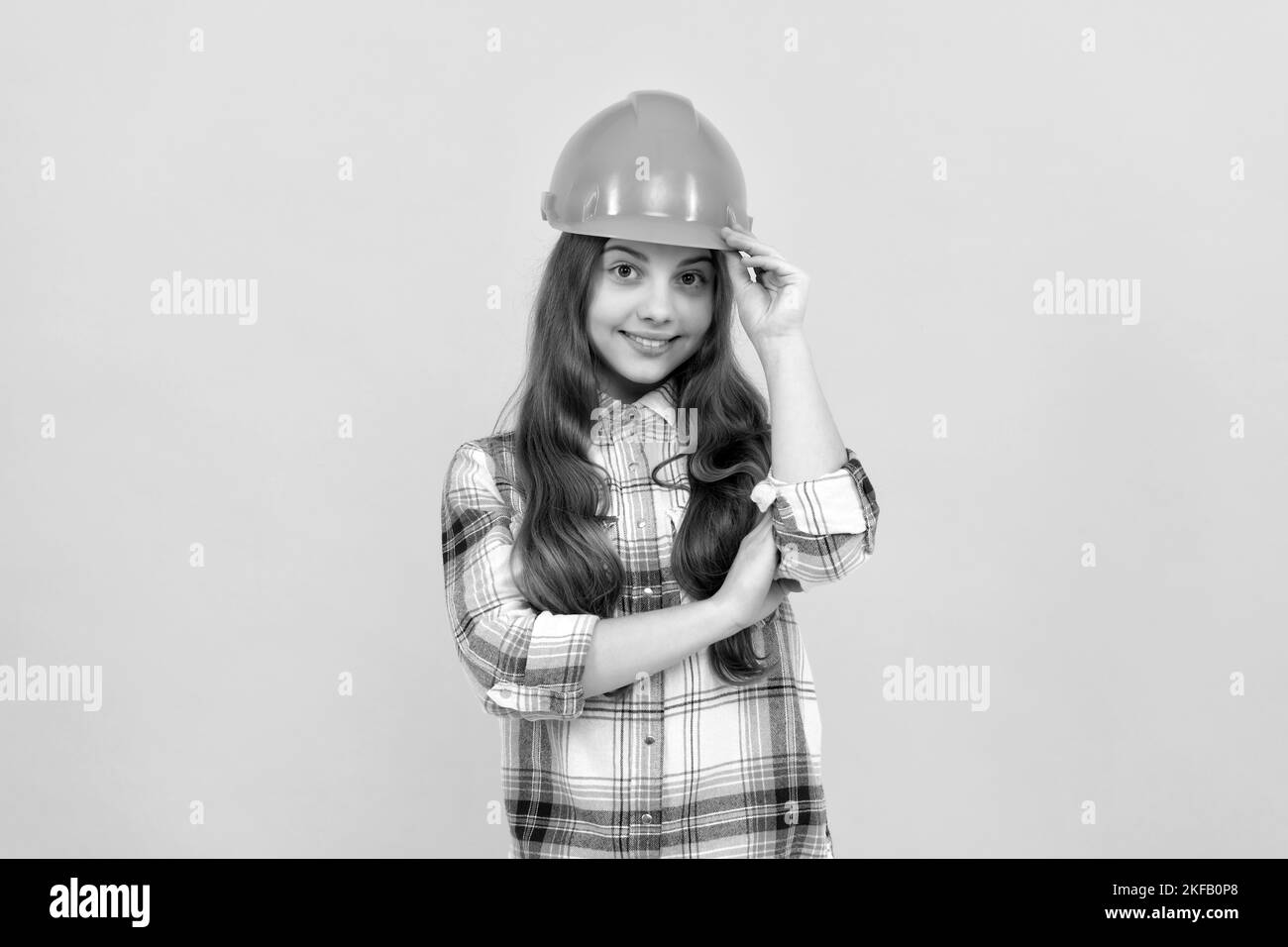 Happy teen Mädchen in Helm und karierte Hemd, Beruf Stockfoto