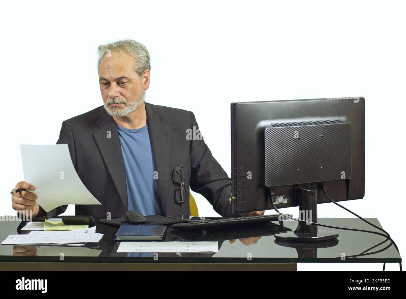 executive Businessman, der mit einem Computer auf einem Desktop auf weißem Hintergrund arbeitet Stockfoto