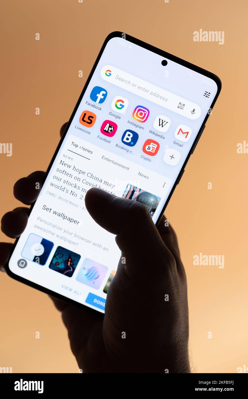 New york, USA - 4. November 2022: Verwendung der Opera Browser App auf dem Smartphone, das auf braunem Hintergrund isoliert in der Hand hält Stockfoto
