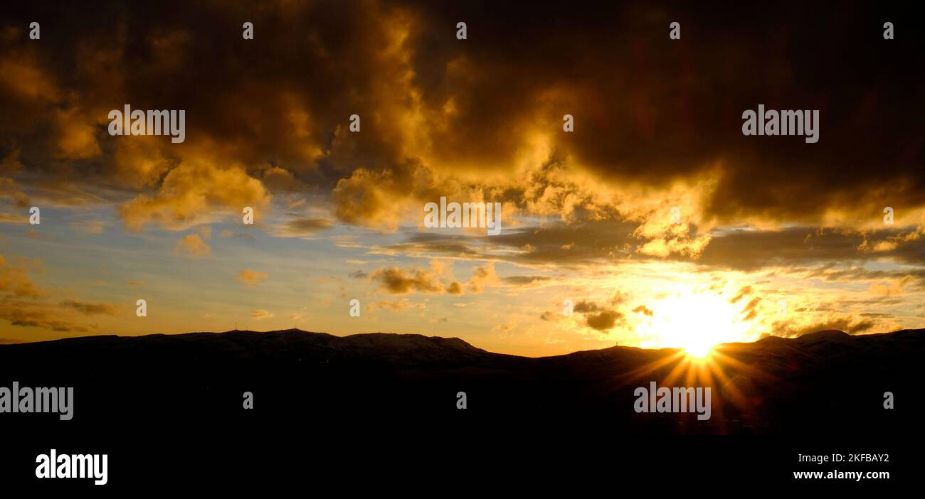 Sonnenuntergang auf Bergen Horizont Wolken sonnenstern Sonnenstern leuchten hell im Himmel Stockfoto