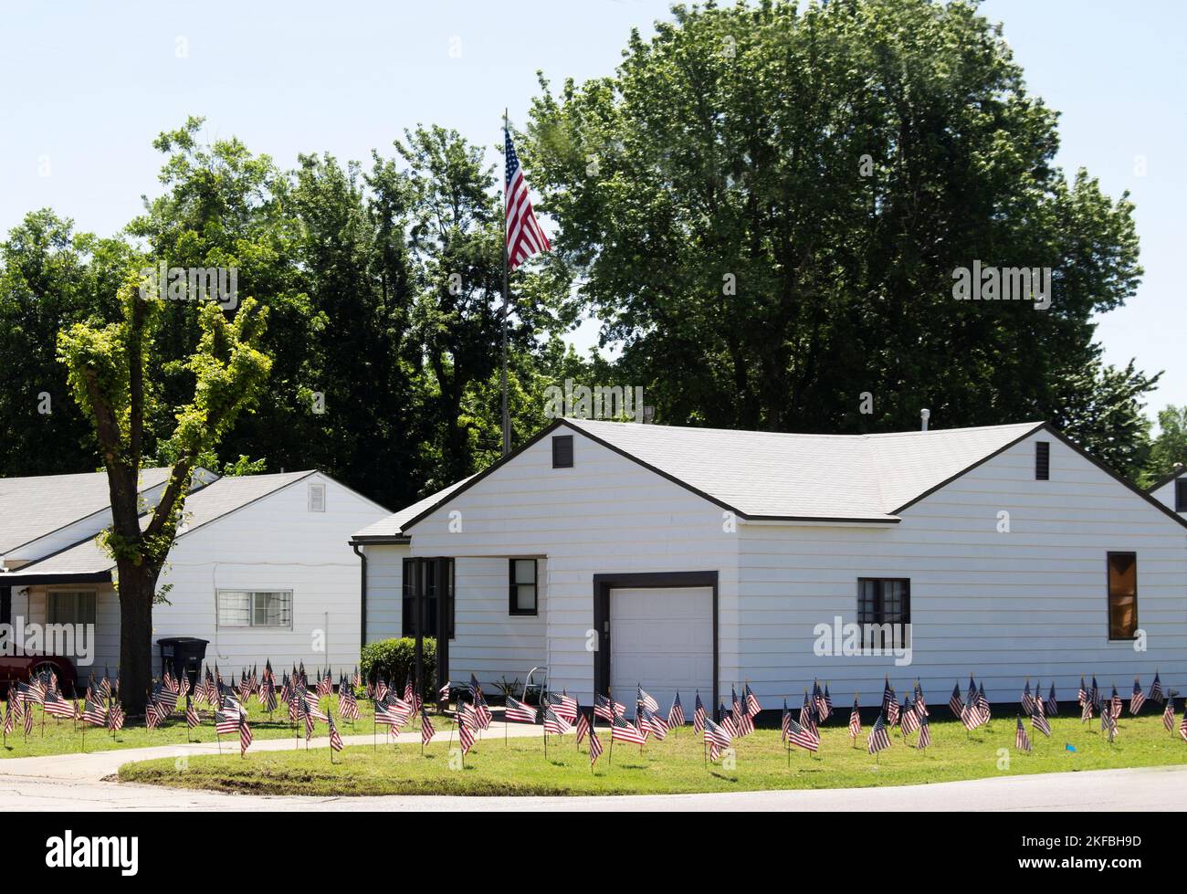 Extremer Patriotismus - kleines weißes Haus mit hundert amerikanischen Flaggen im Hof Stockfoto