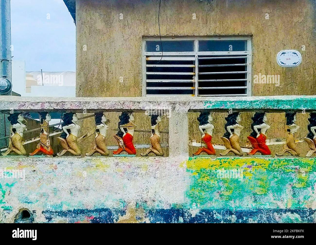 Bunte Beton Meerjungfrau Zaun um Mexican House über bunten Wand Stockfoto