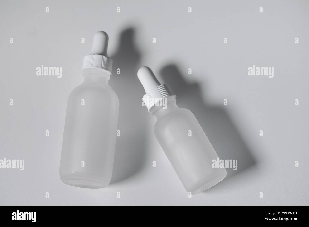Modell einer glasflasche mit tropfdeckel in weiblichen händen