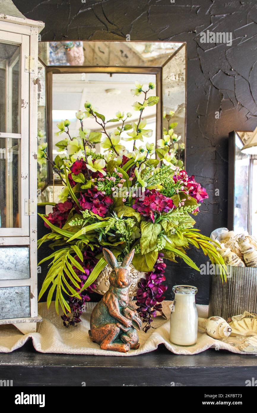 Noch leben von schönen Blumen arrangiert auf dem Tisch mit Antiquitäten und Spiegeln und MoMA Kaninchen und Hase dekorativen Stück. Stockfoto