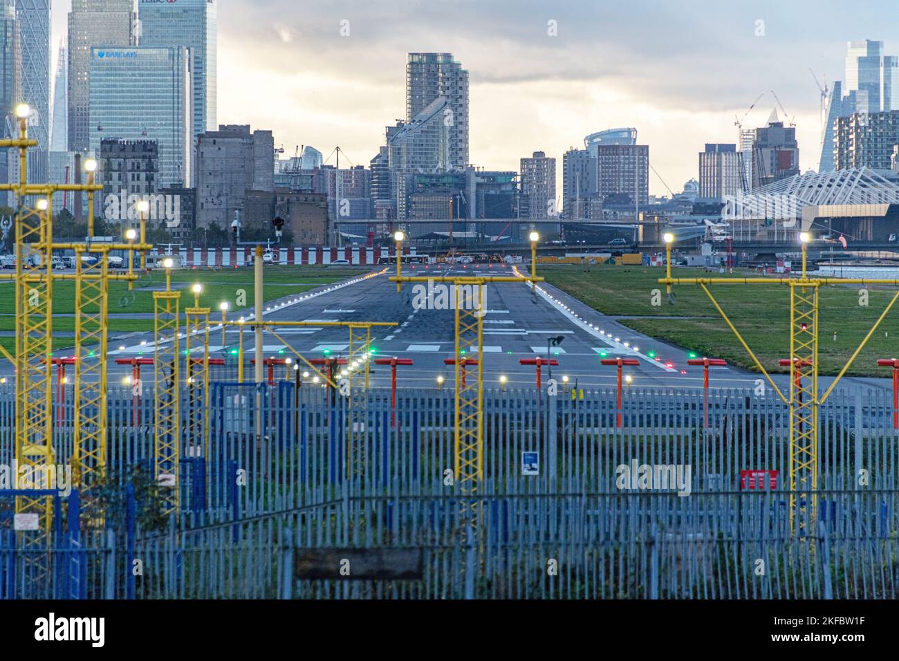 Eine leere Start- und Landebahn bei Sonnenuntergang, mit Blick auf Canary Wharf, London City Airport. Stockfoto