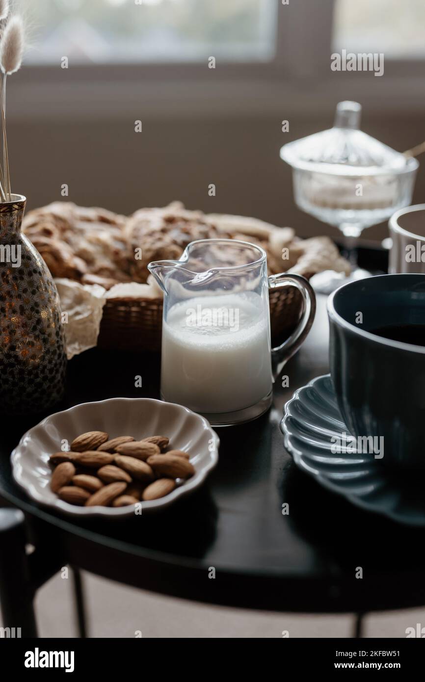 Ästhetisches Frühstück. Milchkaffee, Milchtee, Zucker, Mandel-, Mandelkuchen, Kekse, Marzipane und Puffs. Englisches Frühstück in einem gemütlichen Zuhause. Herbststimmung. Stockfoto