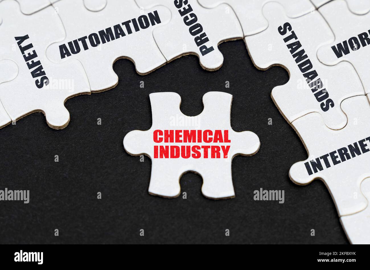 Branchenkonzept. Auf einem schwarzen Hintergrund, Puzzles mit Inschriften, auf einem separaten Puzzle gibt es eine Inschrift - Chemische Industrie Stockfoto