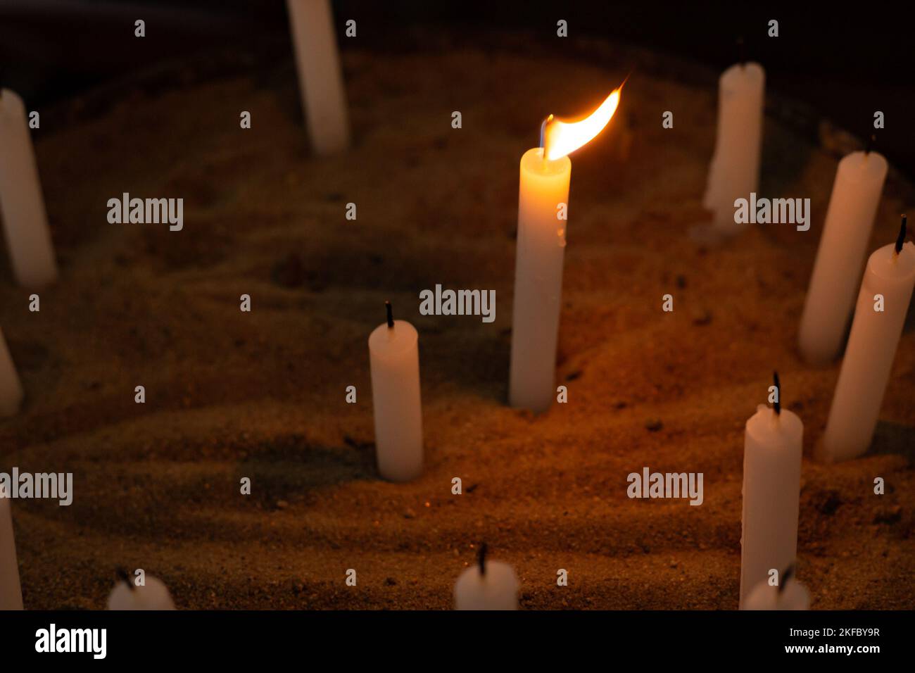 Goiânia, Goias, Brasilien – 12. November 2022: Mehrere Kerzen in einem Sandhalter in der Kirche. Eine Kerze entzündete sich und andere Kerzen wurden nicht angezündet. Kerzen. Stockfoto