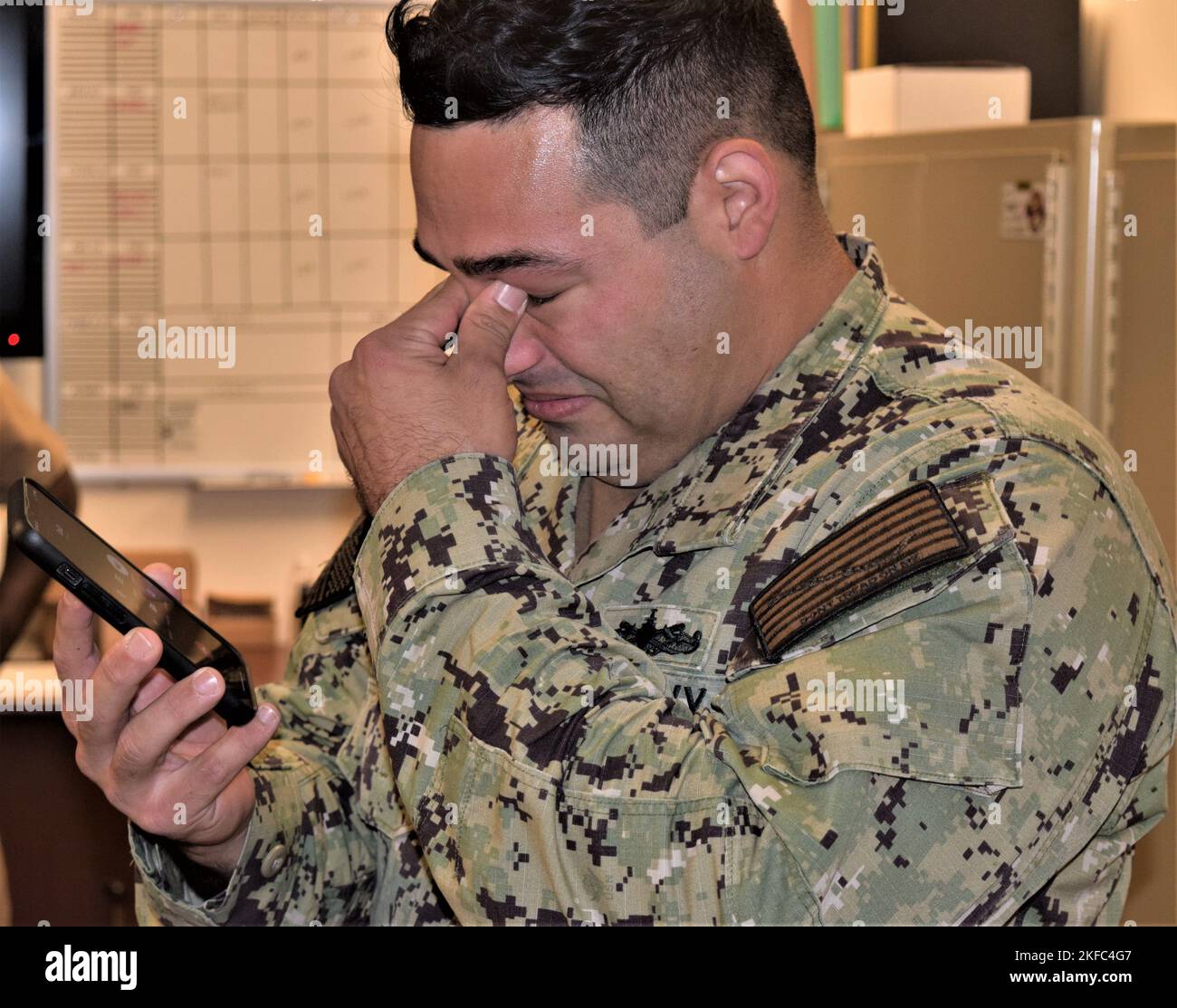 Für Gunners Mate 1. Class Tristan Brayman, der die Nachricht erhielt, dass er zum Chief Petty Officer von Capt. Patrick Fitzpatrick, Naval Hospital Bremerton Director und NMRTC Bremerton Commanding Officer und Command Master Chief James B. May, mit seiner Frau und seinem Sohn, ausgewählt wurde, Er meinte sofort, seinen Vater, einen pensionierten Chief Information Systems Technician, zu rufen und seine guten Nachrichten mitzuteilen (offizielles Navy-Foto von Douglas H Stutz, NHB/NMRTC Bremerton Public Affairs Officer). Stockfoto