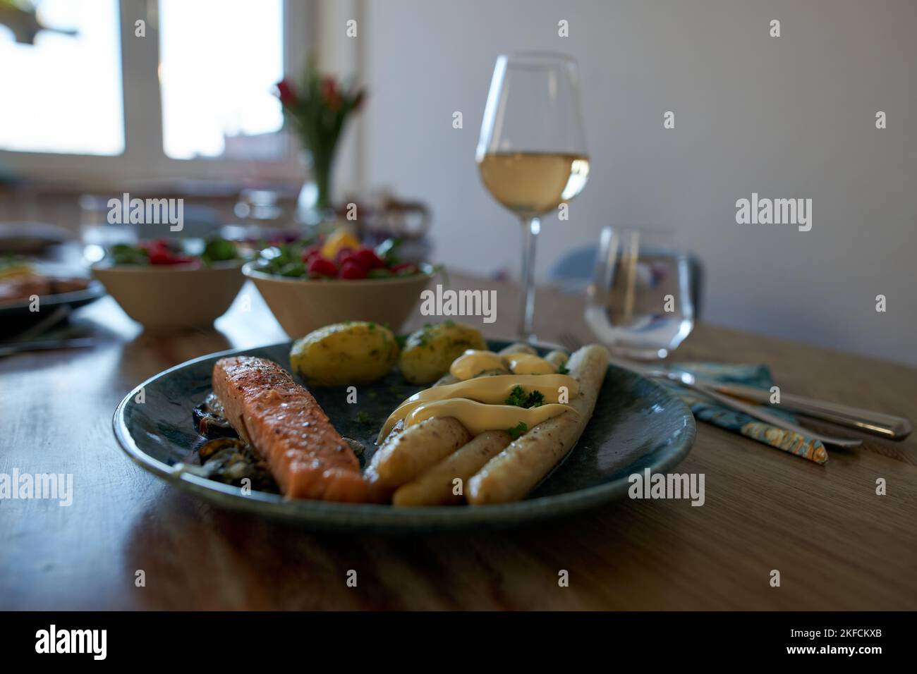 Eine Nahaufnahme aus gedämpften Kartoffeln, flämischem Spargel und gebackenem Lachs auf einem Teller Stockfoto