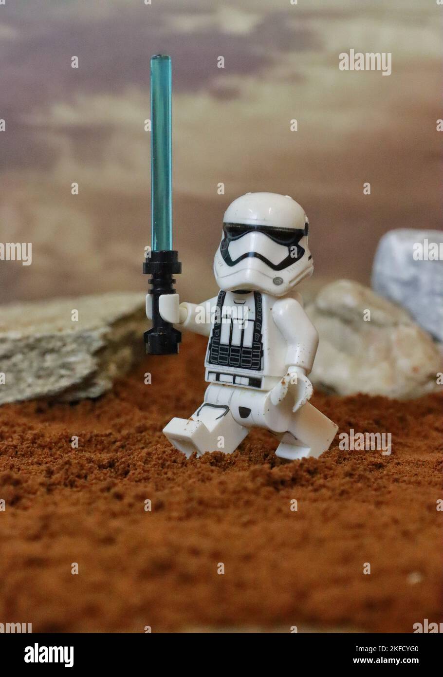 Eine Figur des Sturmsoldaten-Spielzeugs, die mit einem Lichtschwert mit Felsen im Hintergrund marschiert Stockfoto Eine Figur des Sturmsoldaten-Spielzeugs, die mit einem Lichtschwert mit Felsen im Hintergrund marschiert Stockfoto