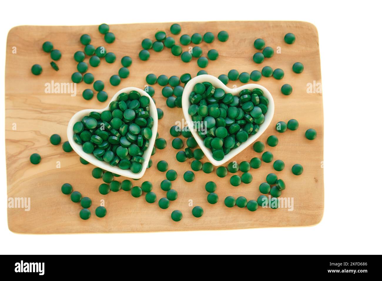 Spirulina Algen Tabletten auf einem Brett auf weißem Hintergrund.Nahrungsergänzungsmittel für einen gesunden Lebensstil. Vitamine und Nahrungsergänzungsmittel. Stockfoto