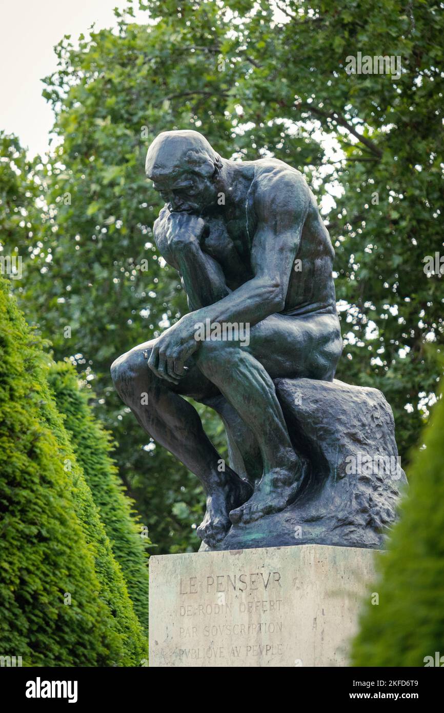 Eine vertikale Aufnahme der von grünen Bäumen umgebenen Denker-Statue in Paris, Frankreich Stockfoto