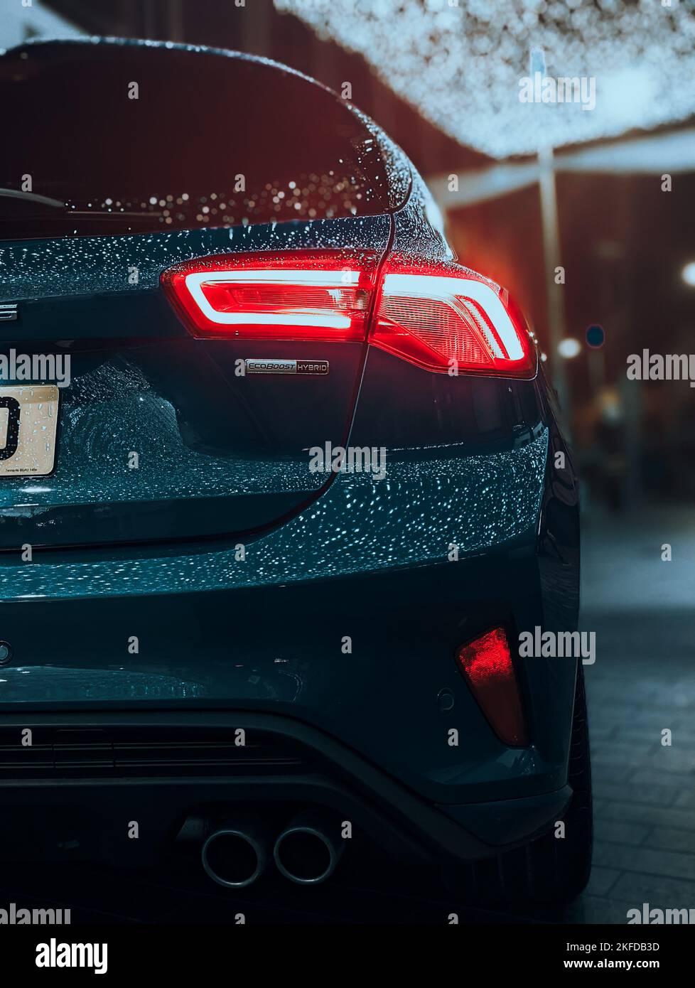 Eine vertikale Aufnahme eines Ford MK4 Autos mit Wassertropfen nach dem Regen unter den Lichtern der Stadt Stockfoto