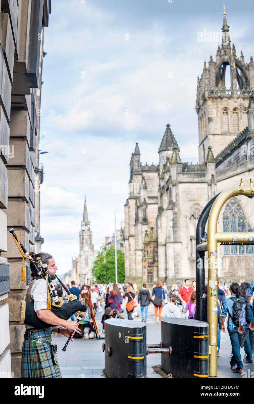 Edinburgh, Schottland-Juli 30 2022:Ein schottischer Pfeifenspieler in traditioneller schottischer Kleidung,Buschs für Touristen und Passanten,neben Sicherheitsbarrieren,durin Stockfoto