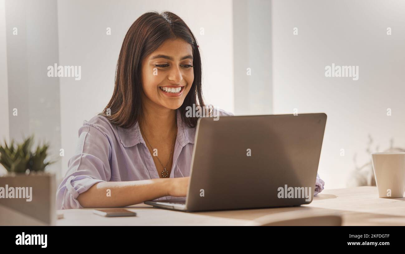 Internet, Laptop und Frau aus Indien im Heimbüro, glückliche freiberufliche Mitarbeiterin am Schreibtisch. Indische Startup-Geschäftsfrau mit Lächeln, Technologie und Online Stockfoto